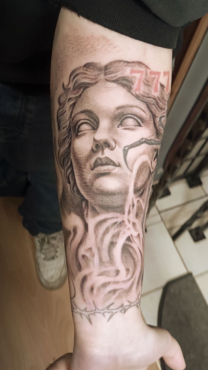 Schwarzgrau-Tattoo – Venus de Milo Skulptur mit Marmorstruktur auf dem Unterarm