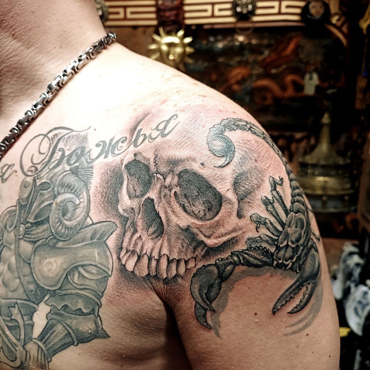 Schwarzgrau-Tattoo – verwitterter Totenkopf mit zwei Raben auf dem Unterarm