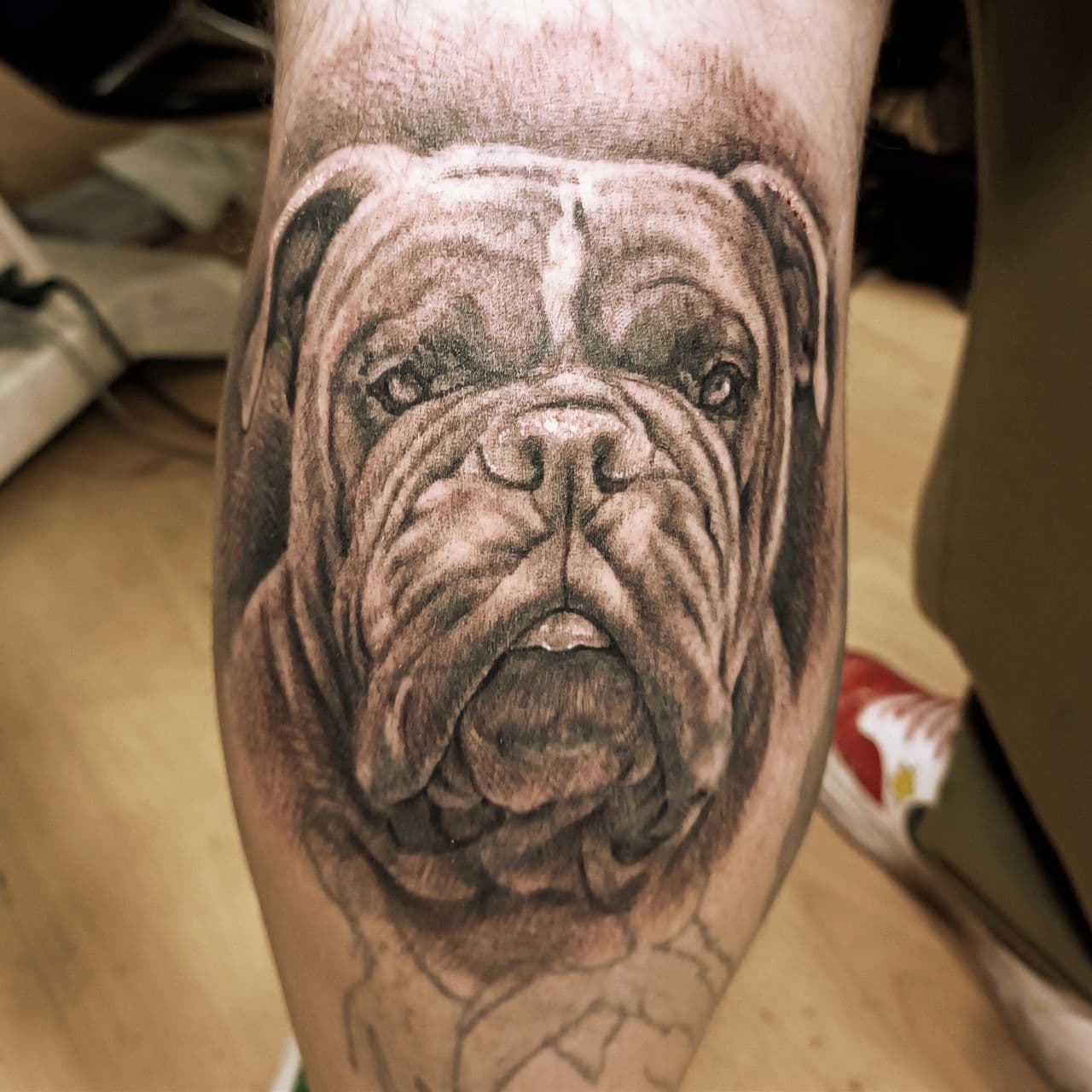 Schwarzgrau-Tattoo – heulender Wolf im Mondlicht auf dem Oberarm
